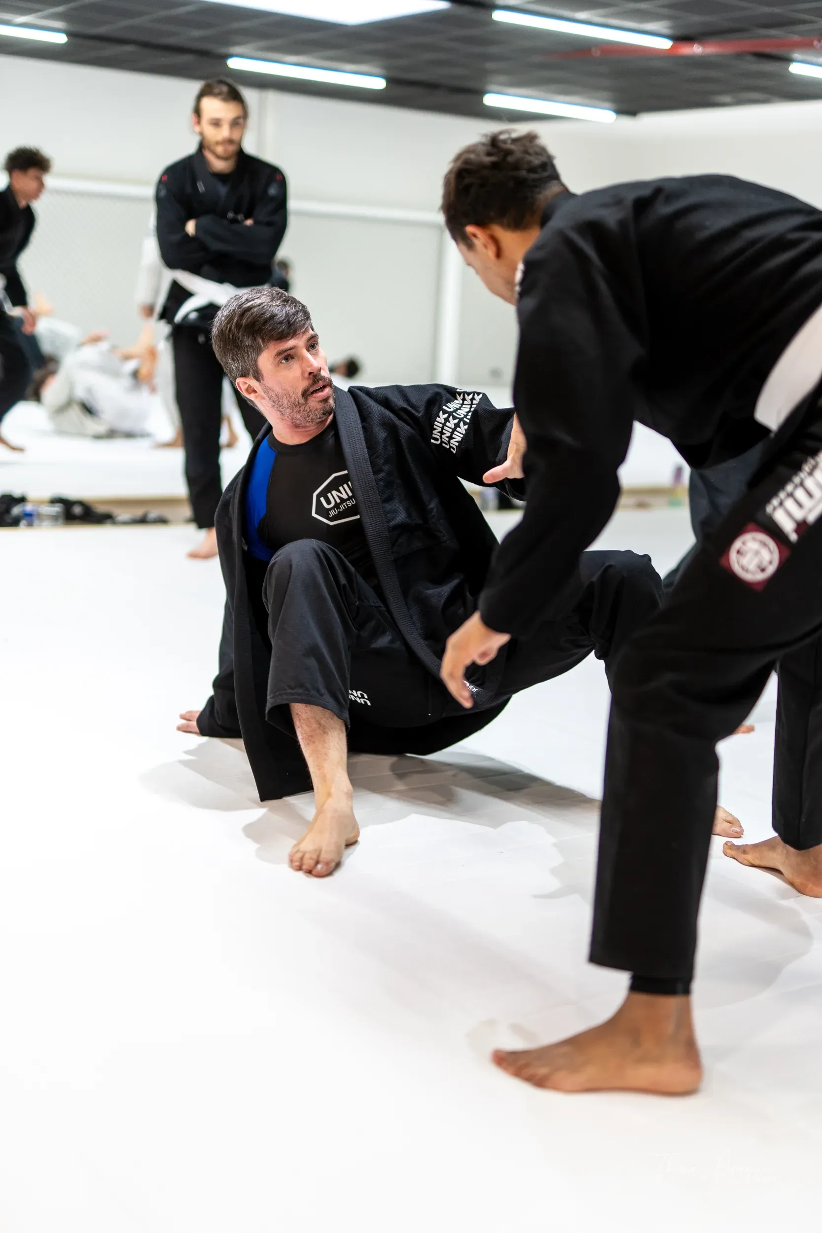 Un coach UNIK debout au milieu du tatami pendant un cours