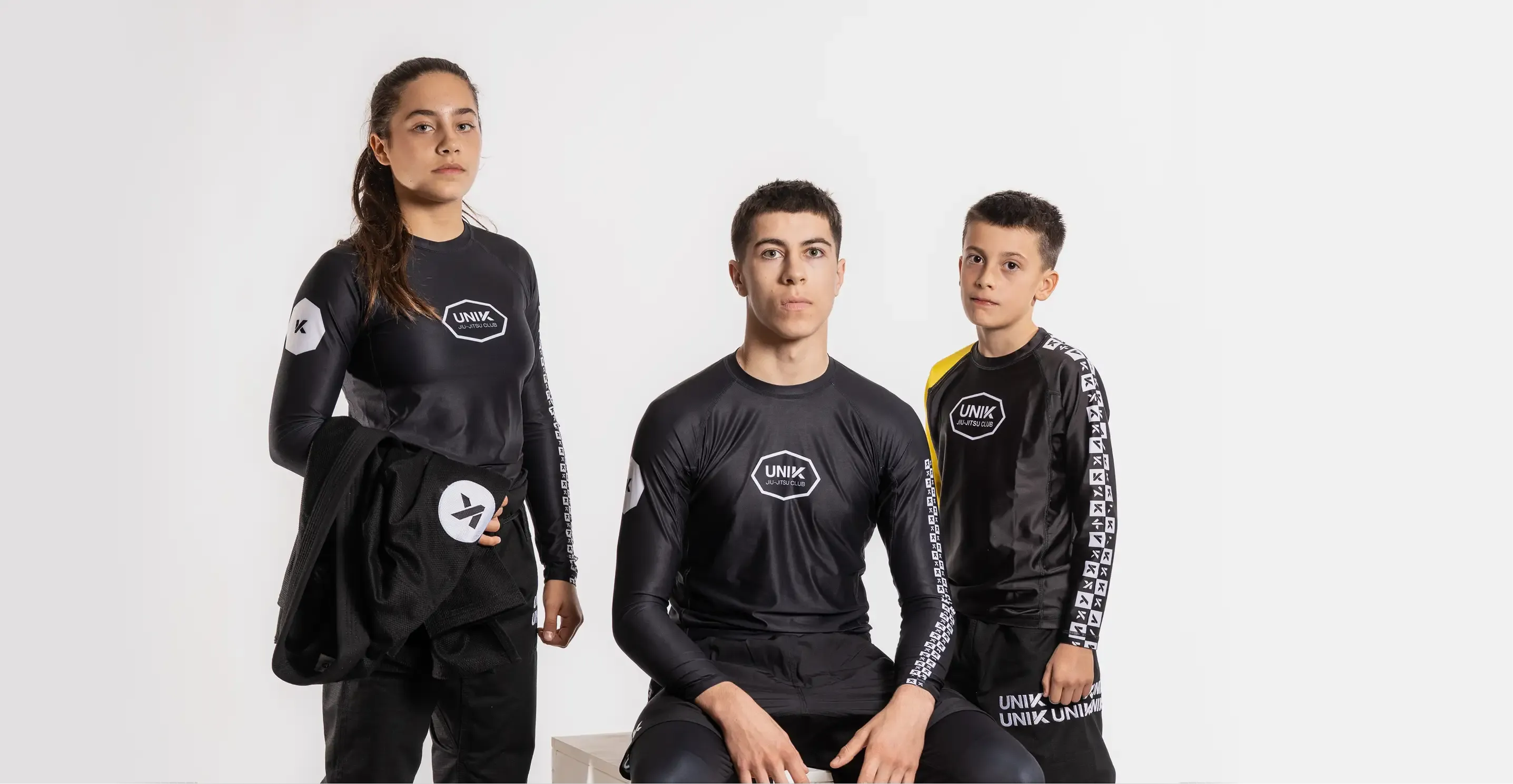 Trois pratiquants UNIK en rashguards du club, photo studio